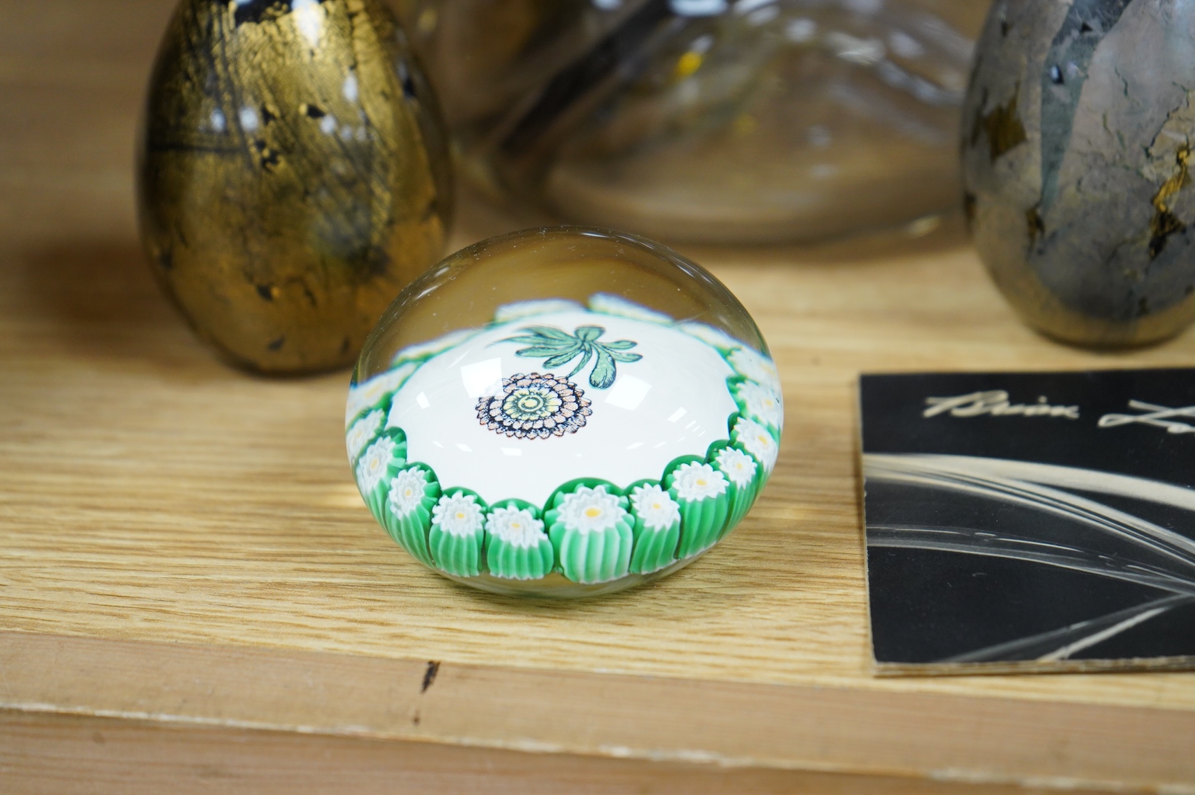 Brian Lonsway (American), an art glass ornamental dish, two Isle of Wight glass eggs and a floral paperweight, tallest 8.5cm